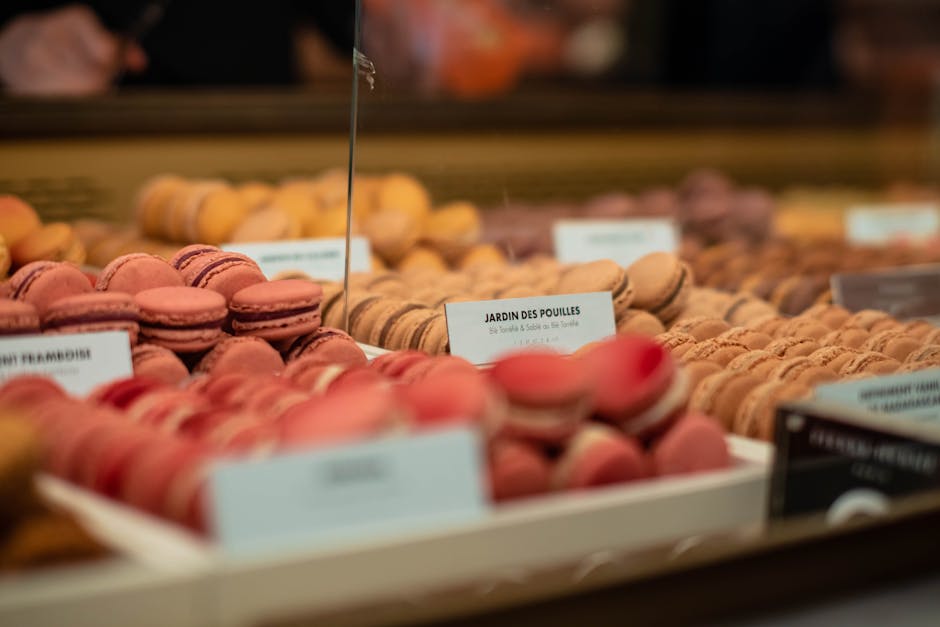 Vibrant macarons on display in a Paris market bakery, showcasing a variety of flavors.
