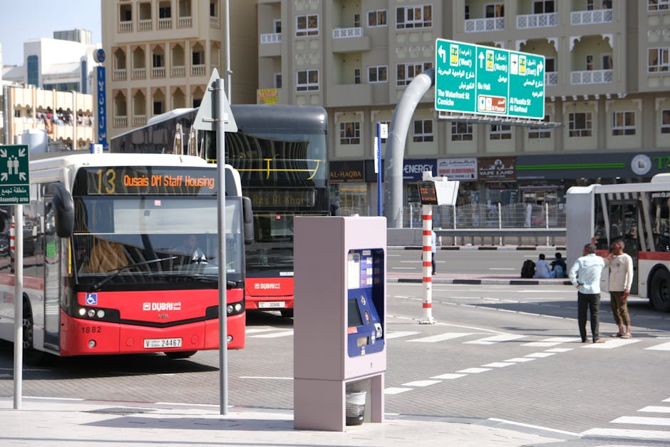 Buses at a bustling transit hub in Dubai, showcasing urban architecture and transportation.