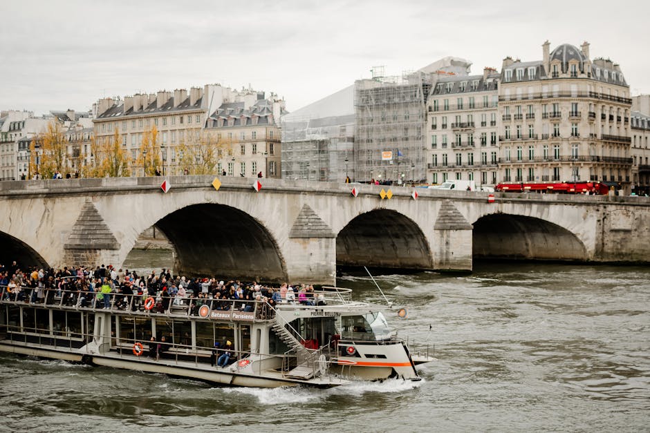 Tourists enjoy a picturesque ride on the Seine River with views of Parisian architecture and bridges.