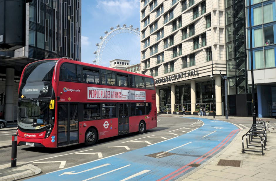 A classic red double decker bus in London with the London Eye in the background, showcasing urban life.