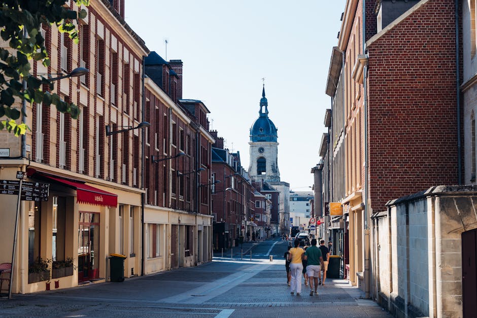 Charming street in Amiens, France with a view of the Notre-Dame Cathedral's distant spire.